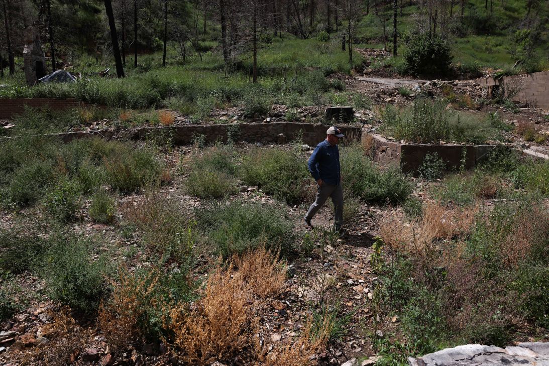 Leroy Smith walks through the remains of his family’s home following a wildfire in Ruidoso on August 28.