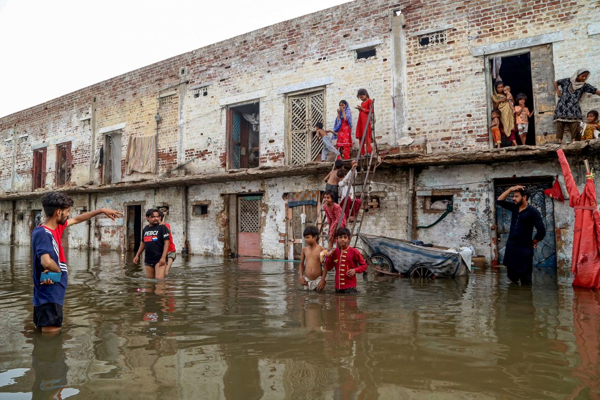 Residents gather outside their flooded homes in Hyderabad, Pakistan, on July 15.