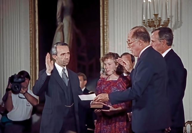 Souter raises his right hand as Supreme Court Chief Justice William Rehnquist delivers the oath of office in October 1990. Family friend Erin Rath is holding the Bible.