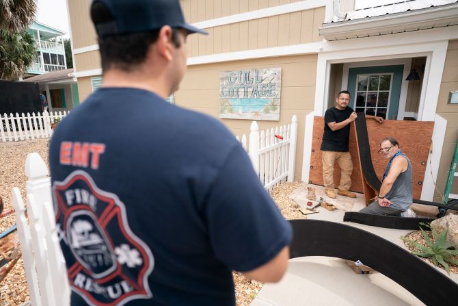 A Wakulla County firefighter speaks to residents of Panacea, Florida, while making note of those who were not evacuating on September 25.