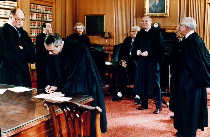 Souter signs documents after being sworn in. With him, from left, are Rehnquist, Antonin Scalia, Sandra Day O'Connor, Thurgood Marshall, Anthony Kennedy, Harry Blackmun and John Paul Stevens.