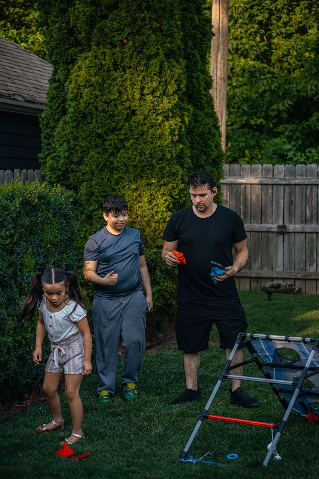 Bub, right, plays yard games with his children Baylee and Michael III during a family barbecue.
