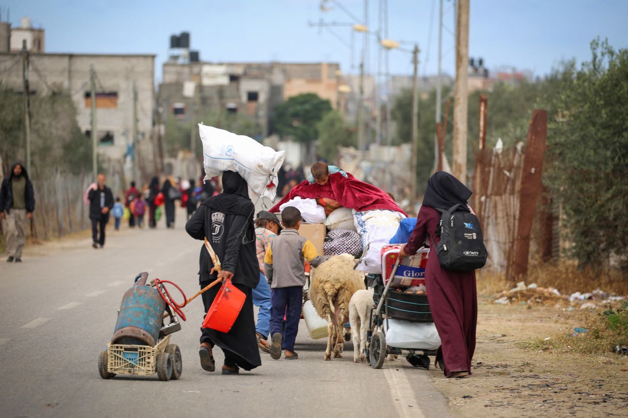 Displaced Palestinians carry their belongings on May 6 as they leave Rafah following an evacuation order.