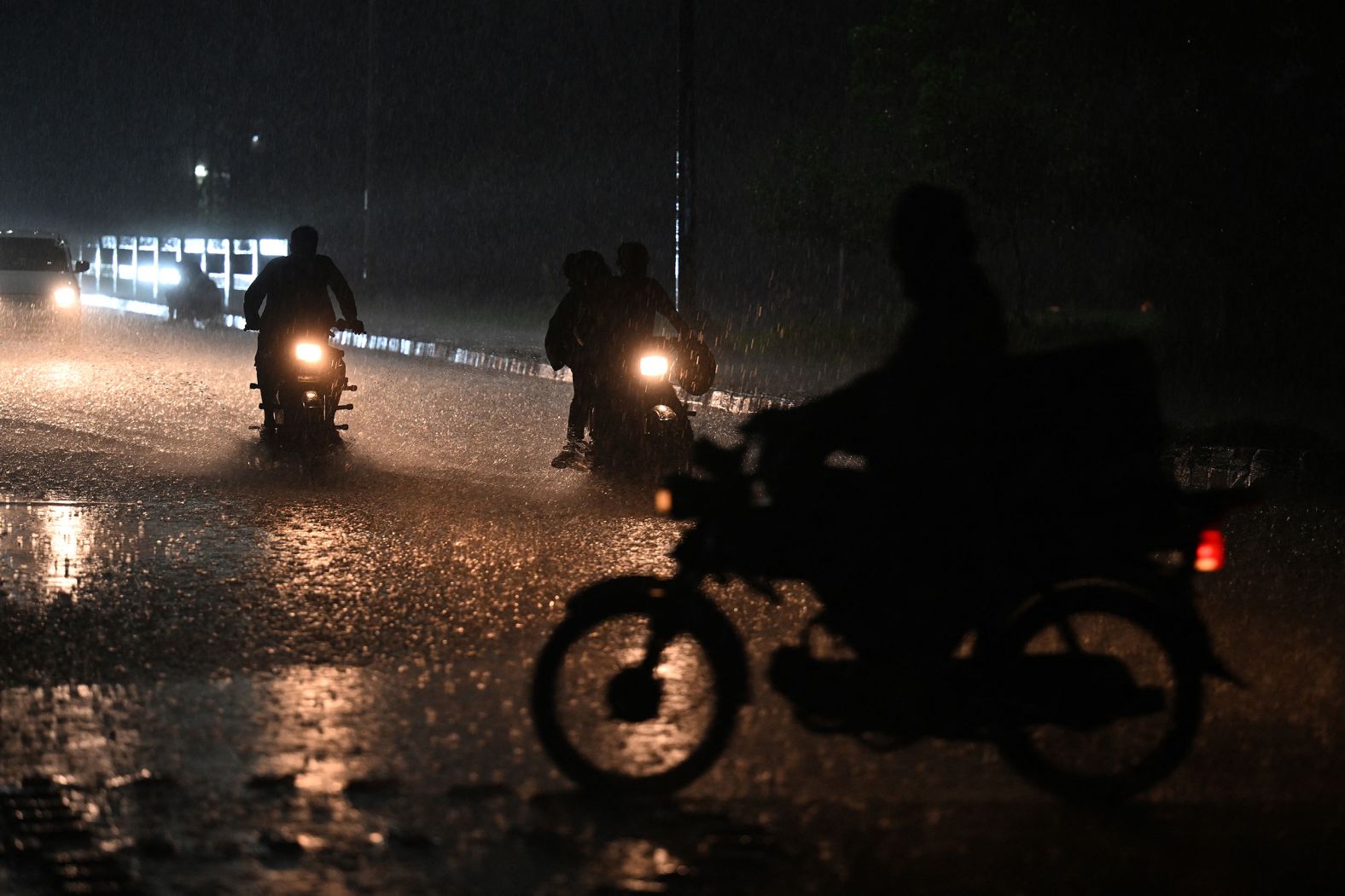 Commuters drive down a street in Islamabad, Pakistan, during heavy rainfall on July 6.