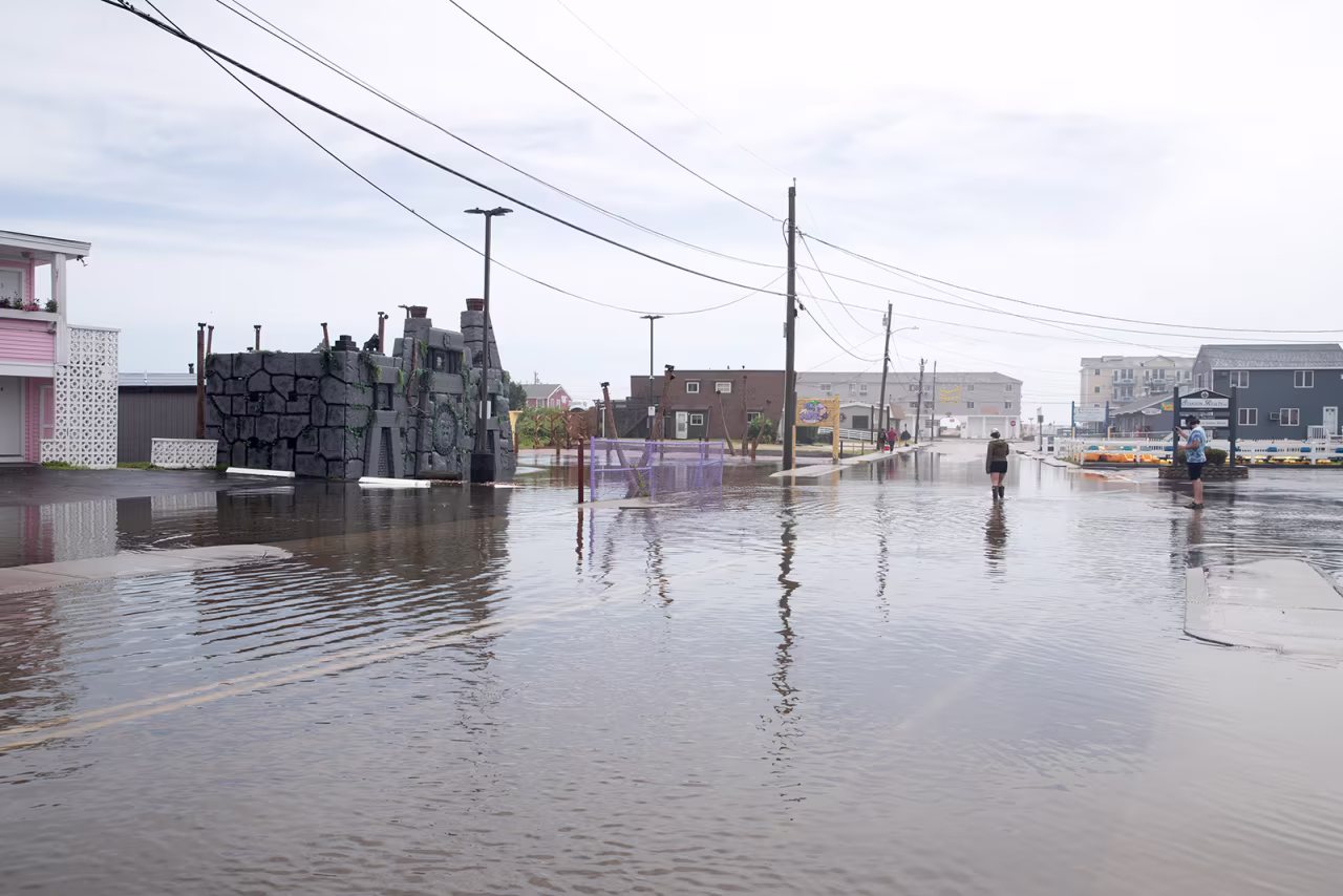 A person walks on a flooded road during Tropical Storm Henri on August 22, in Westerly, Rhode Island. 