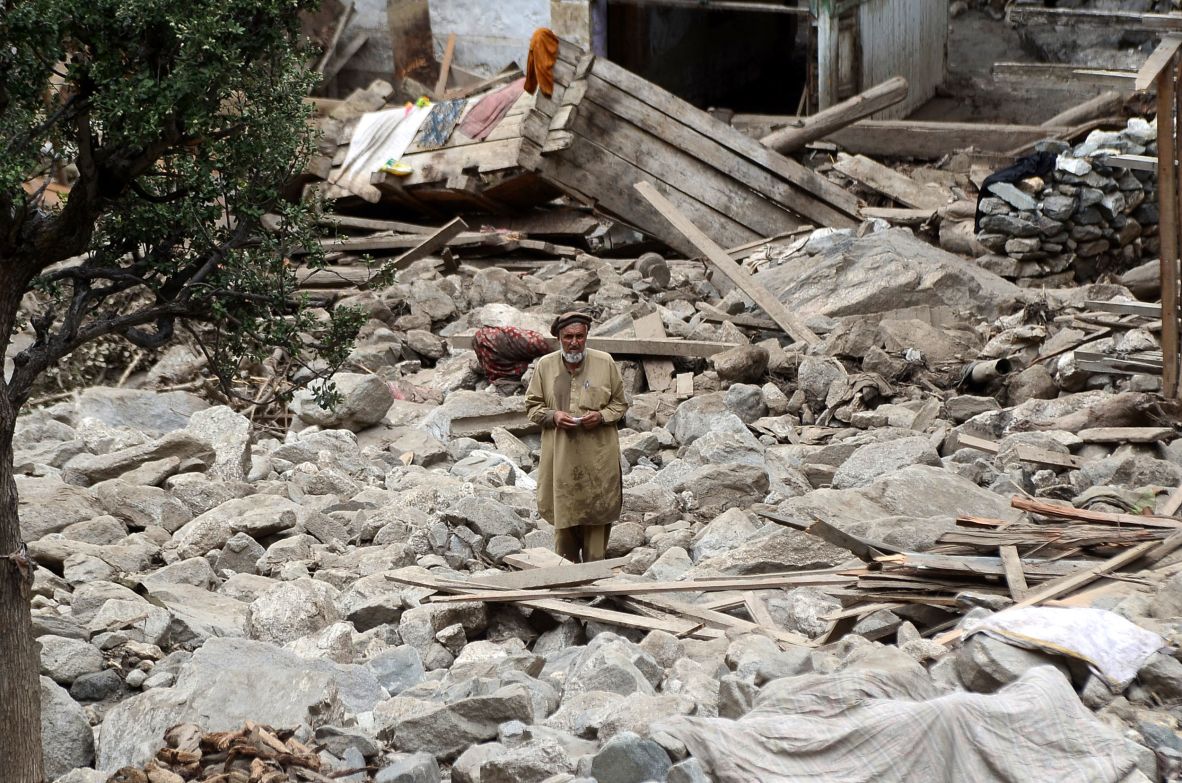 A man stands among debris from a flash flood in Gilgit-Baltistan, Pakistan, on July 16.