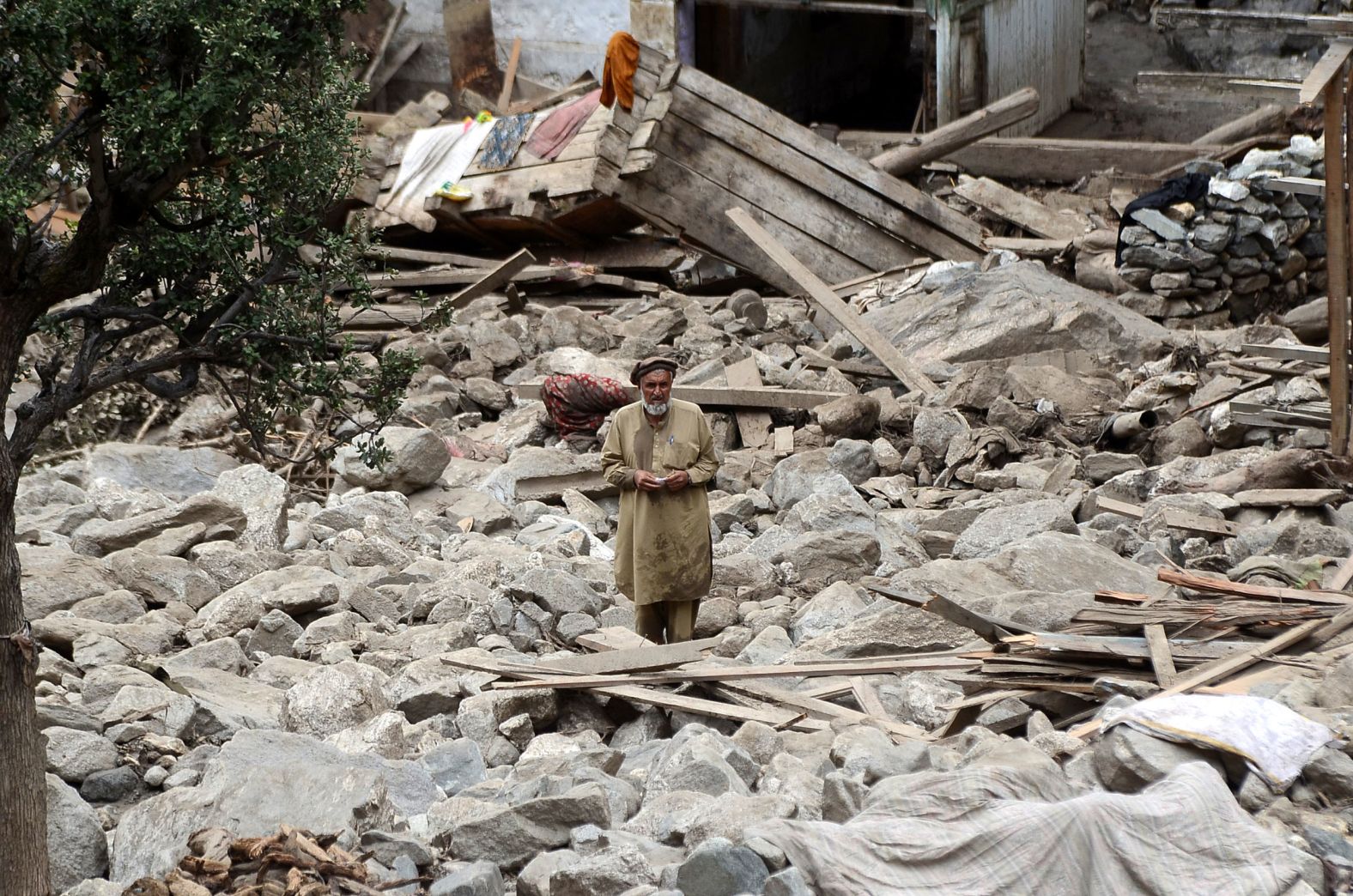 A man stands among debris from a flash flood in Gilgit-Baltistan, Pakistan, on July 16.