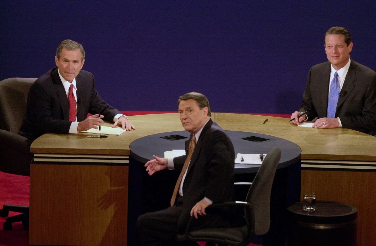 From left, Bush, moderator Jim Lehrer and Gore look up during a technical issue at the start of a debate in 2000.