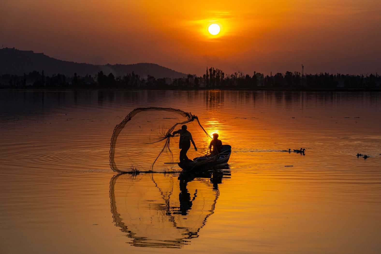 A Kashmiri fisherman casts his net on the Dal Lake in Srinagar, India, on Friday, September 1.