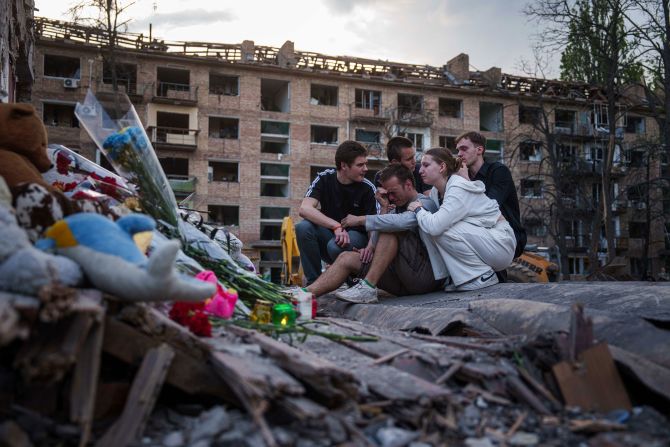 Friends of Danylo Hudya, a 17-year-old who was killed in a Russian strike, gather together at the remains of a house in Kyiv, Ukraine, on Friday, April 25.