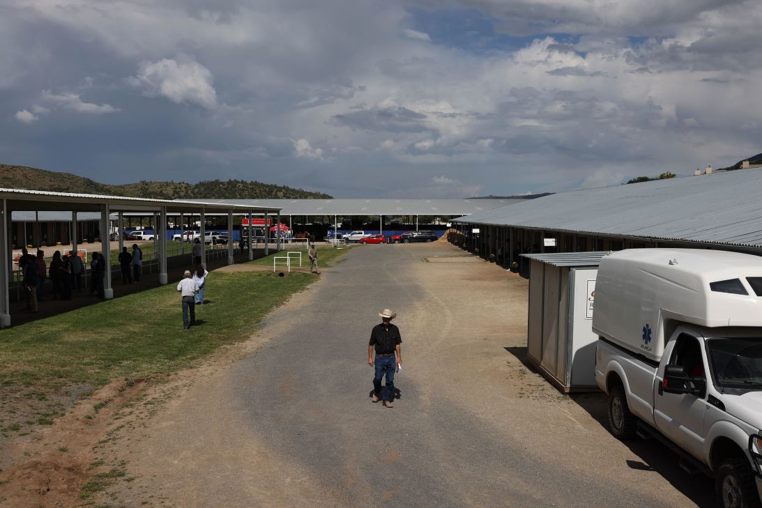 A man walks past horse stalls during the Ruidoso Select Yearling Sale in Ruidoso Downs on August 29.
