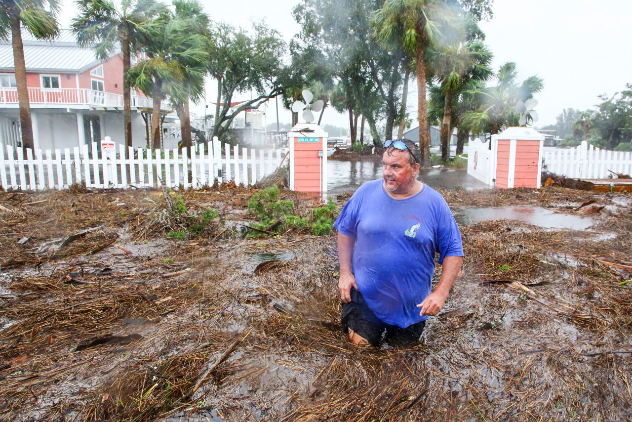 Daniel Dickert wades through water in front of his home in Steinhatchee.