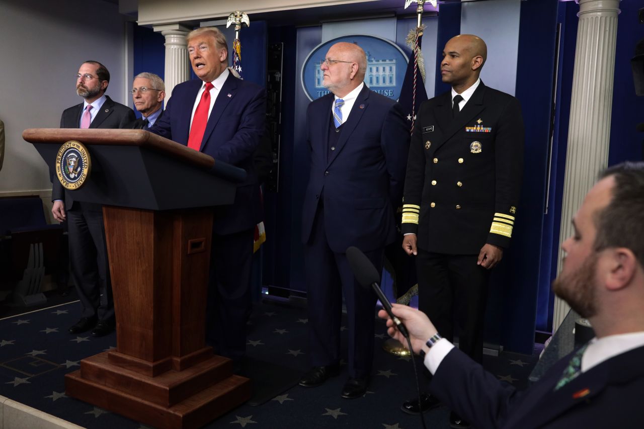 U.S. Surgeon General Jerome Adams, far right, listens as President Donald Trump speaks during a news conference on Saturday, February 29, in Washington, DC.