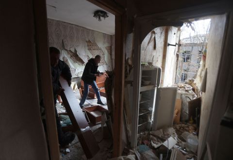 A local resident cleans debris in his apartment after a residential building was hit by a missile strike in Konstantinovka, Ukraine, on October 14. 