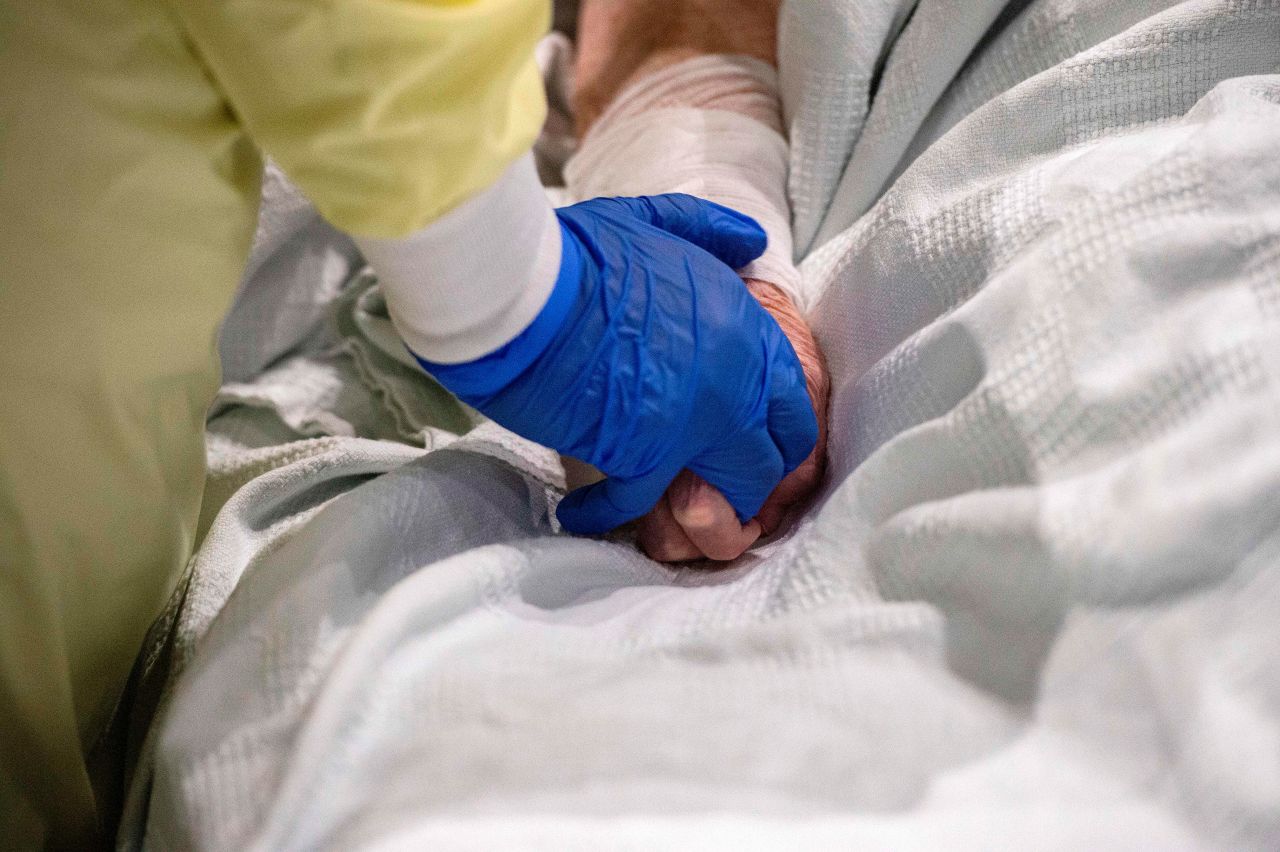 A medical worker cares for and comforts a patient who is?suffering from Covid-19 at UMASS Memorial DCU Center Field Hospital in Worcester, Massachusetts, on January 13.