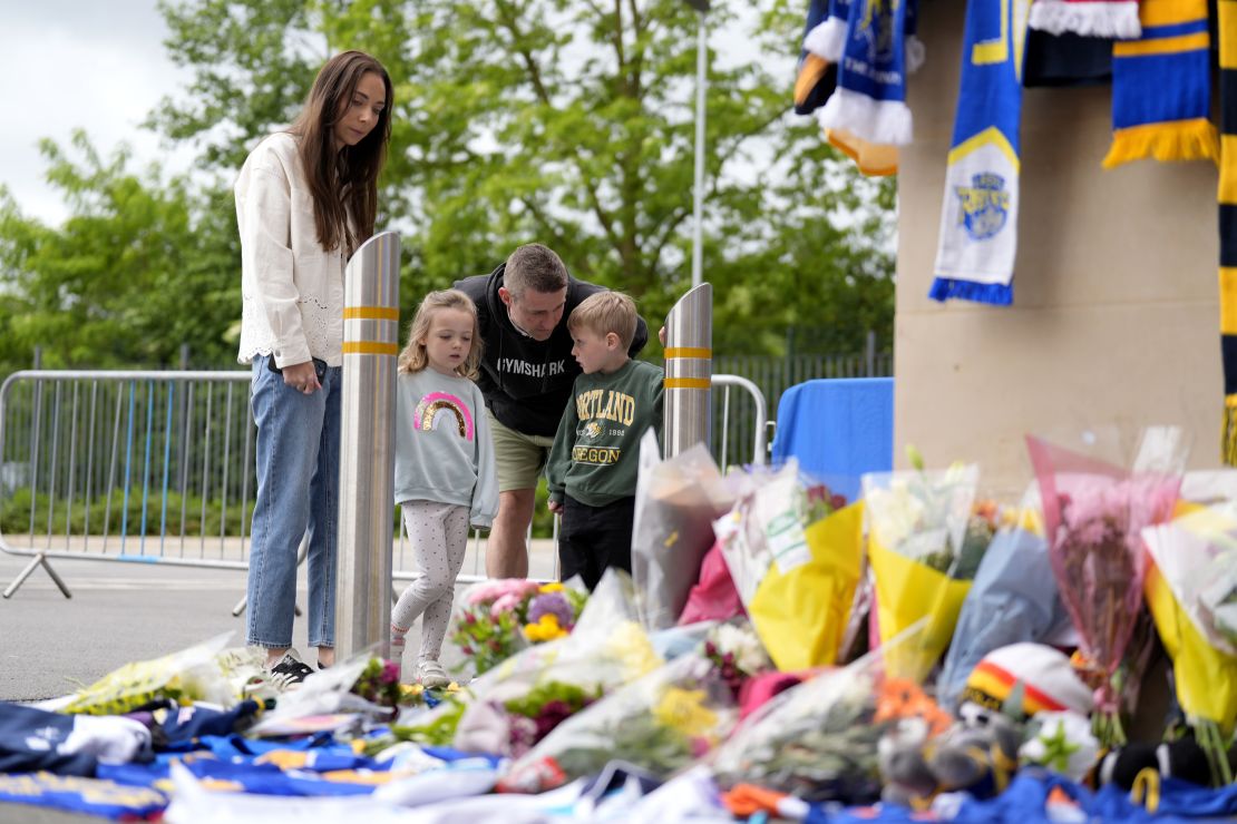Members of the public pay tribute and view flowers and messages left at Headingley Stadium in Leeds.