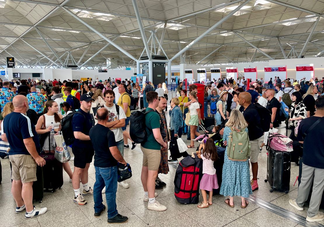 Passengers wait at London Stansted Airport in Essex amid widespread IT outages affecting airlines and other businesses worldwide.