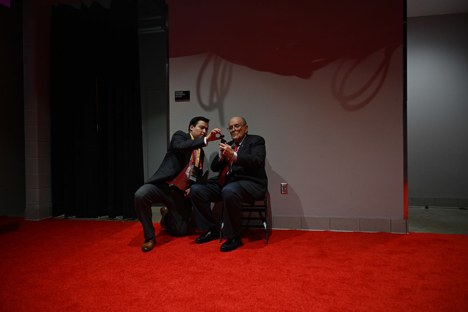 Former New York Mayor Rudy Giuliani, right, gets help with a pocket camera as he attends the convention on Tuesday.