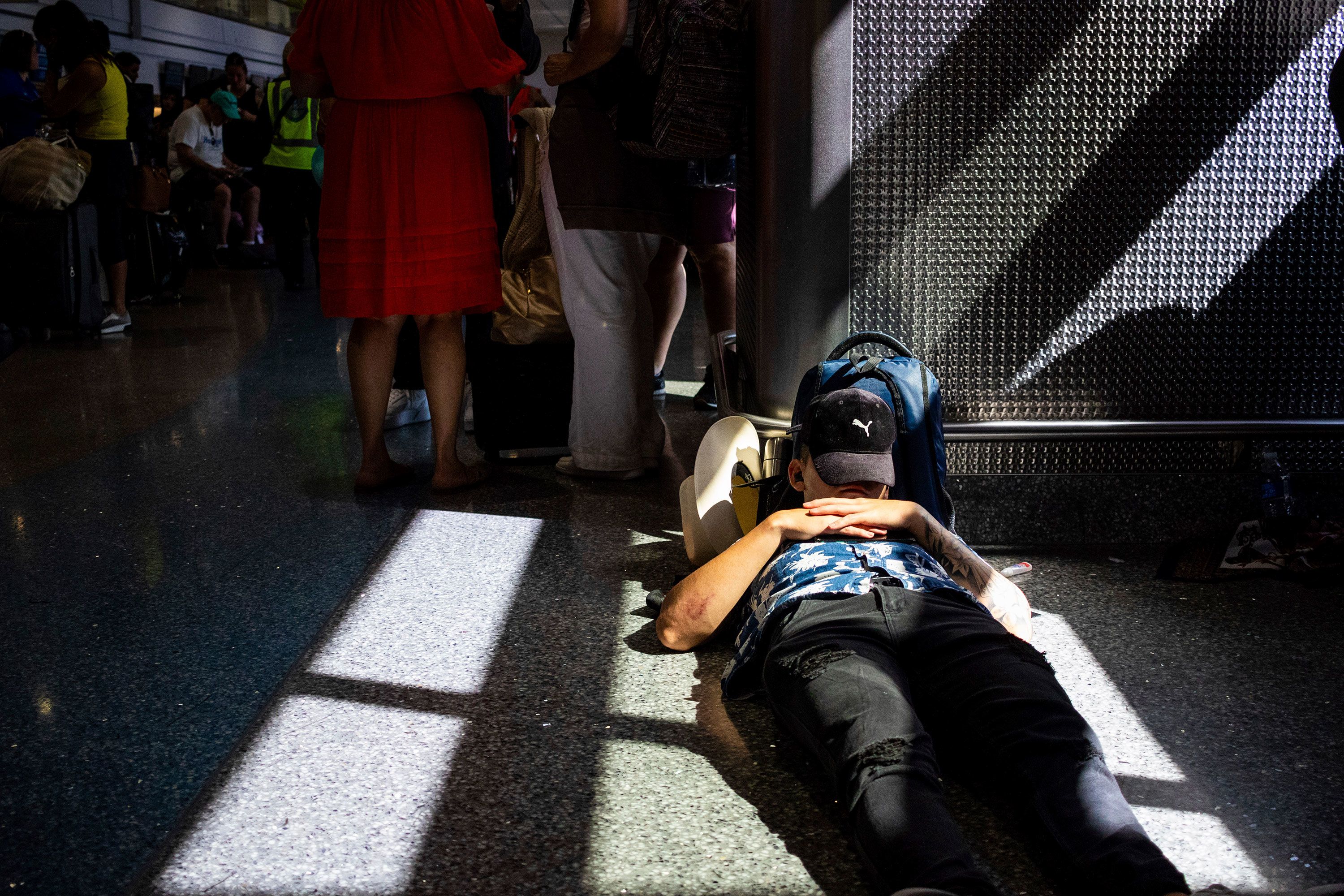 A passenger takes a nap inside a terminal at Las Vegas’ Harry Reid International Airport on Friday, July 19. Many flights into and out of the United States were canceled Friday after a global computer outage affected airports, banks and other businesses.