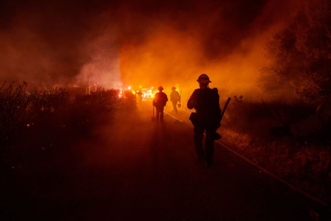 Firefighters work against the advancing Post Fire in Gorman, California, on Sunday, June 16. The wildfire <a href=