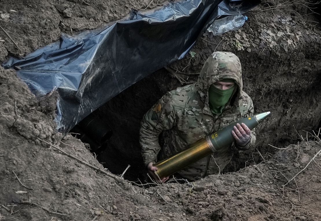 A Ukrainian soldier holds an artillery shell as he prepares to fire a howitzer towards Russian troops near the town of Kreminna, Ukraine March 4, 2024