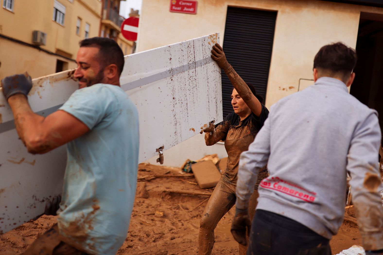 People help clean up in Paiporta on Friday.