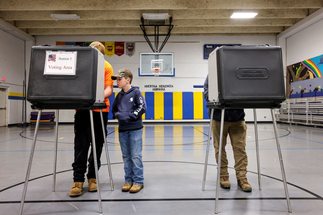 A boy watches his father vote in Asheville, North Carolina, on Tuesday, November 5.