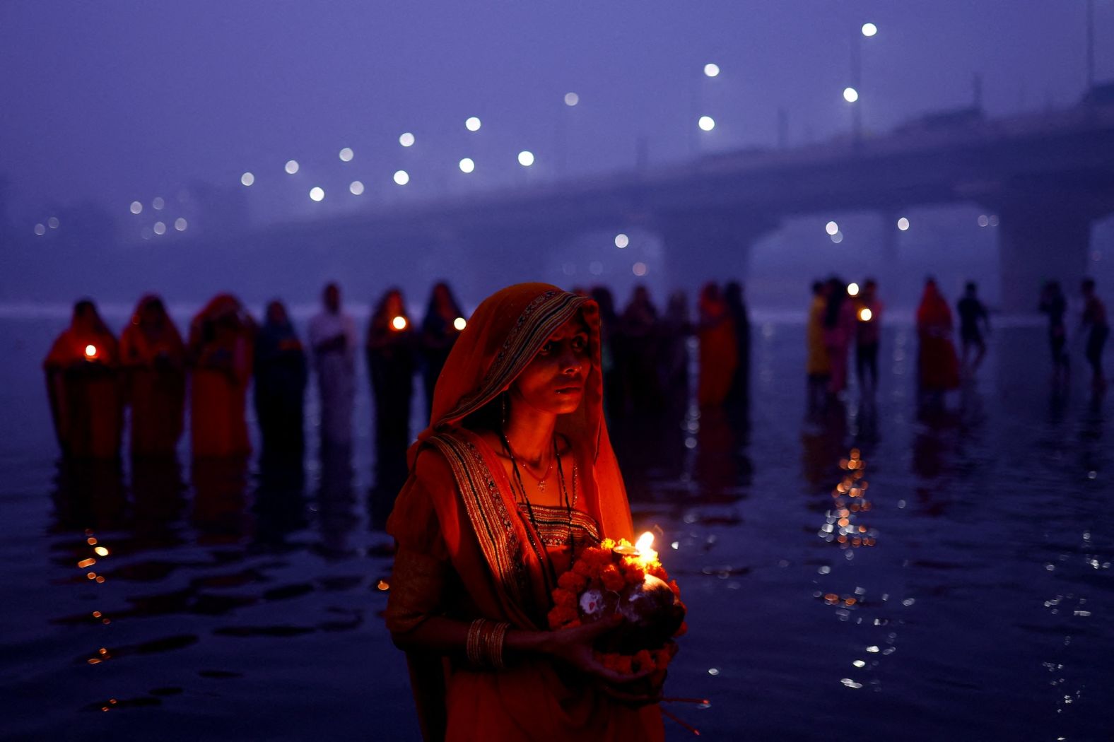 People stand in the Yamuna River in New Delhi during the Hindu festival of Chhath Puja on Friday, November 8.