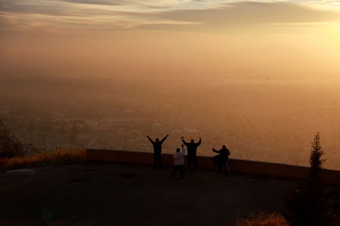 Men exercise as the sun rises over Damascus on December 12.