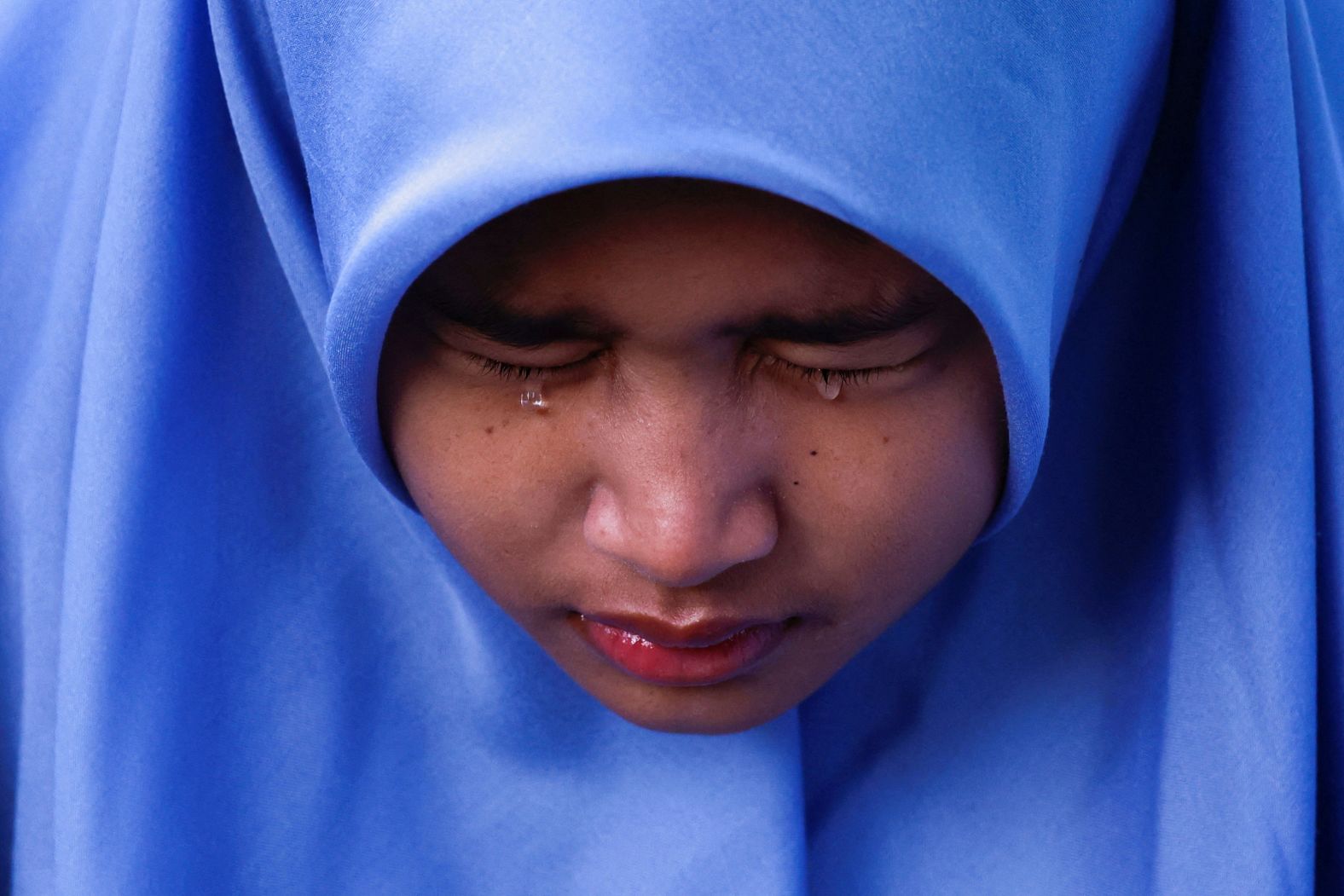 Aisha Rana Zhafirah reacts while visiting the Ulee Lheue mass grave, where many victims of the <a href="index.php?page=&url=https%3A%2F%2Fwww.cnn.com%2F2024%2F12%2F25%2Fworld%2Fgallery%2Fremembering-the-deadliest-tsunami-in-history%2Findex.html">2004 Indian Ocean tsunami</a> are buried in Banda Aceh, Indonesia, on Thursday, December 26. The tsunami was one of the deadliest disasters in modern recorded history, killing an estimated 230,000 people.