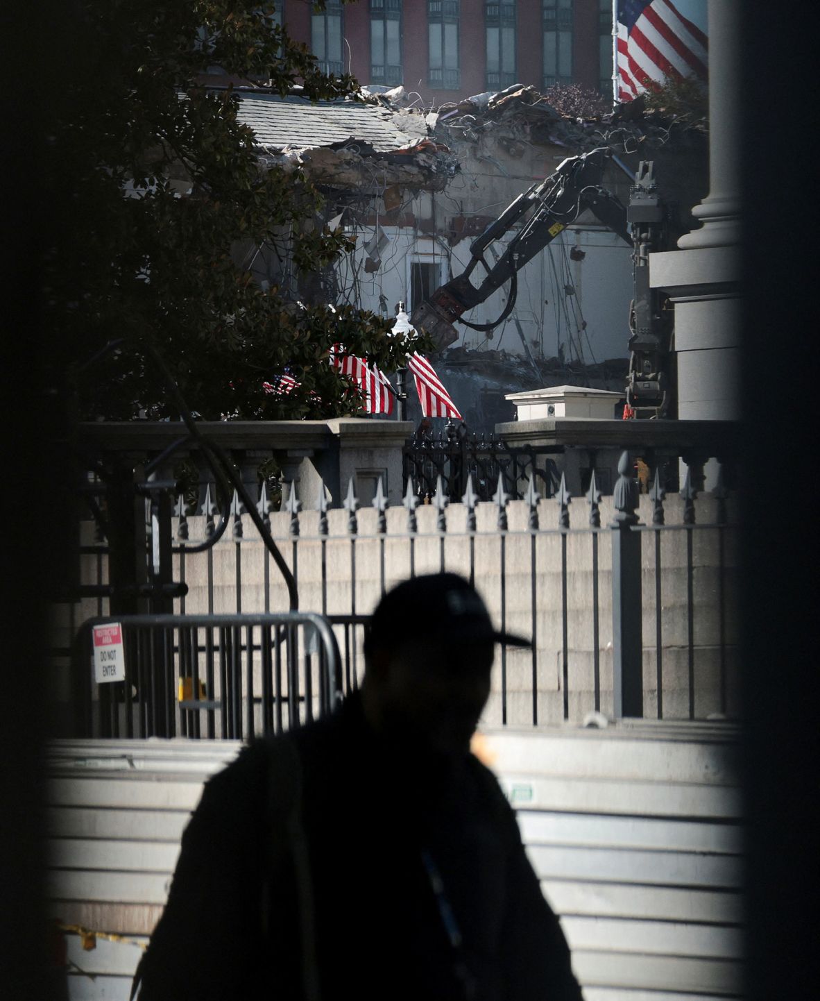 A person walks by the demolition site on October 21.