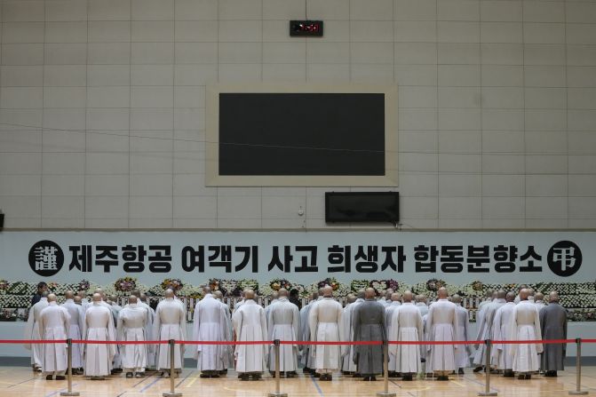 Buddhist monks pray for victims of the crash at a memorial altar at Muan sport park on December 30.