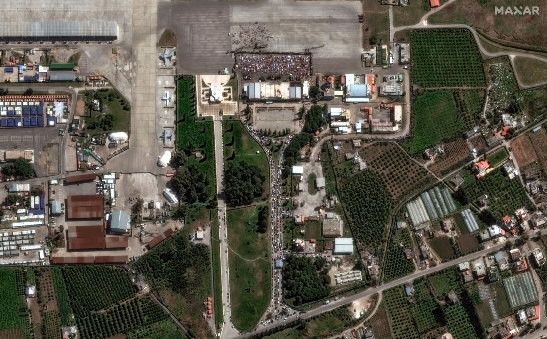 Satellite imagery shared with CNN by Maxar Technologies shows crowds of people and dozens of civilian vehicles at an entrance to Russia’s Khmeimim Air Base near Latakia, Syria, on March 10.