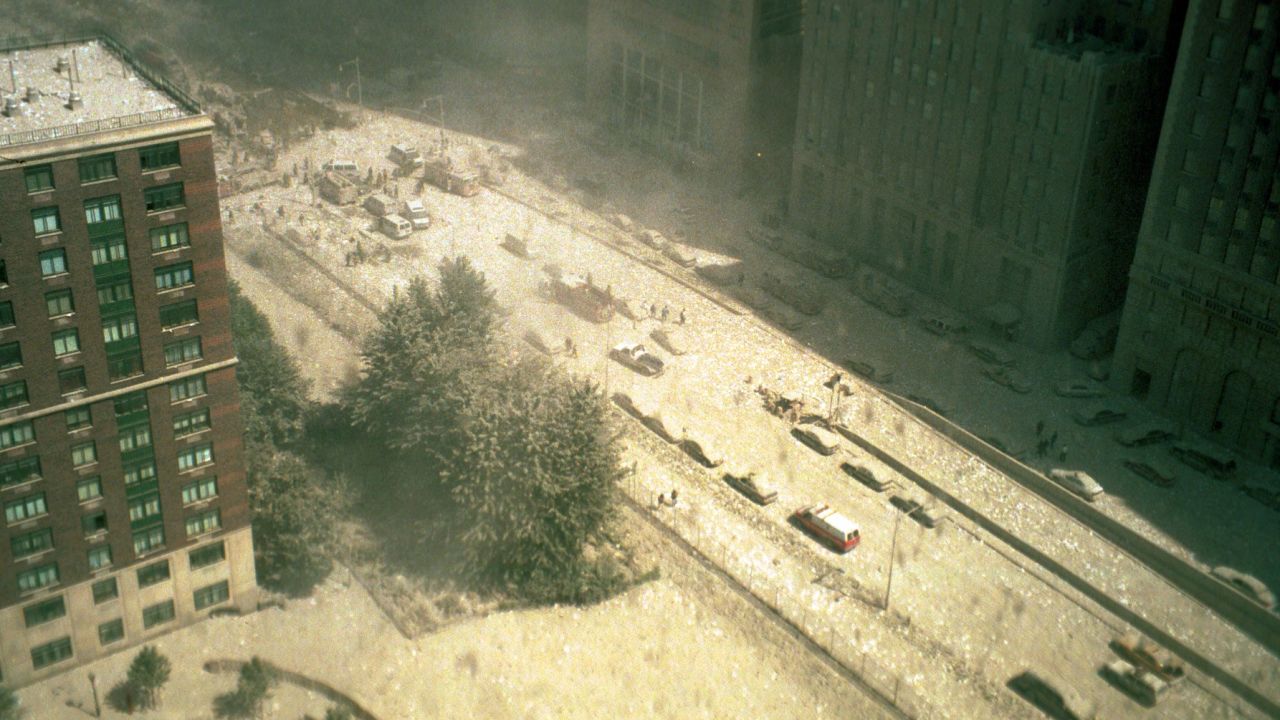 People are seen on the dust-covered street after the collapse of the North Tower on September 11, 2001.