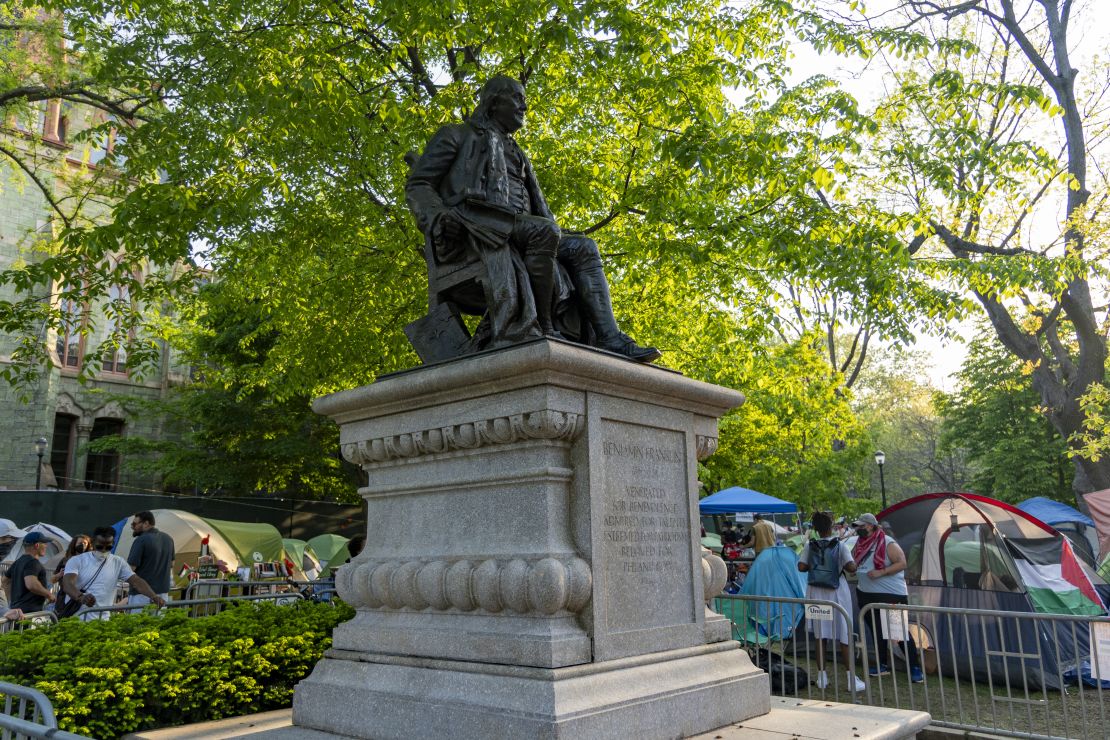 Protesters at the University of Pennsylvania flank a statue of Benjamin Franklin.