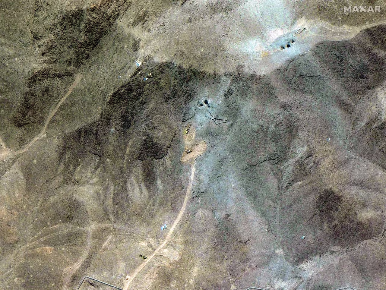 A zoomed out satellite image shows excavators at the tunnel entrances.