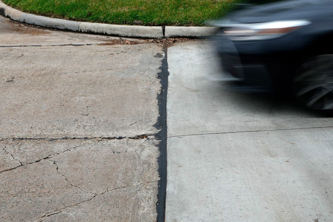 A car drives on a street that straddles Stafford, Texas, and Sugar Land, Texas in November 2023. Stafford, seen at left, abolished its property tax in 1995.