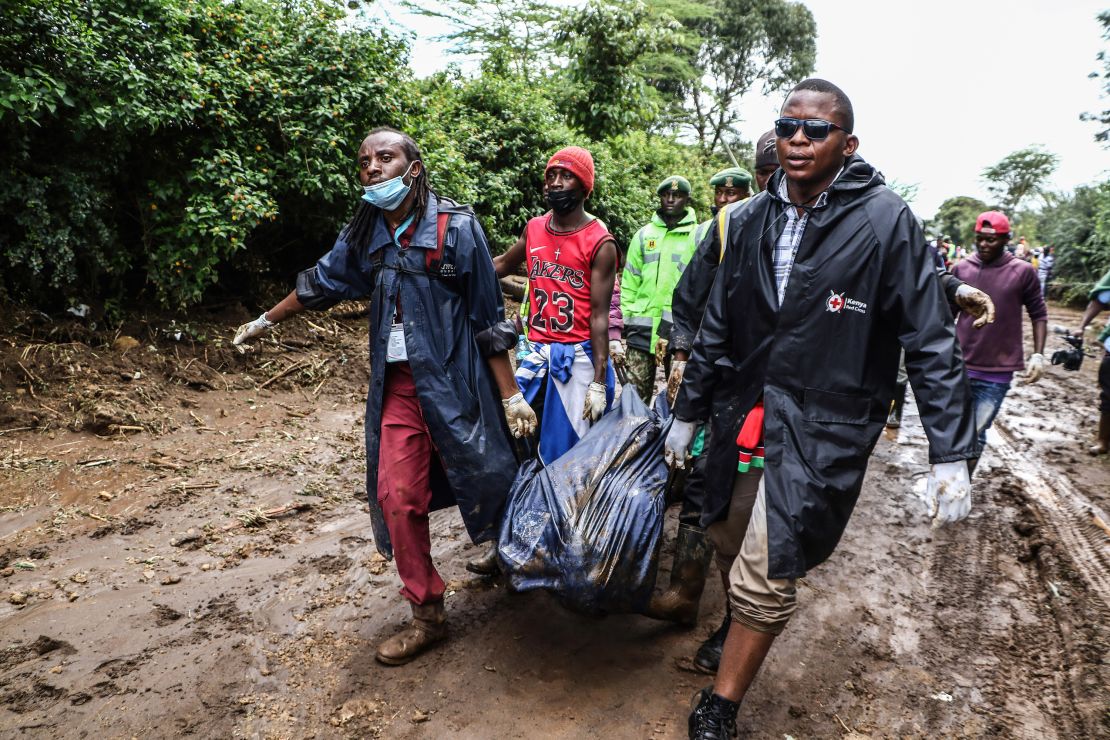 Rescuers carry the body of a young man recovered in the debris following flooding, in Mai Mahiu, Kenya.