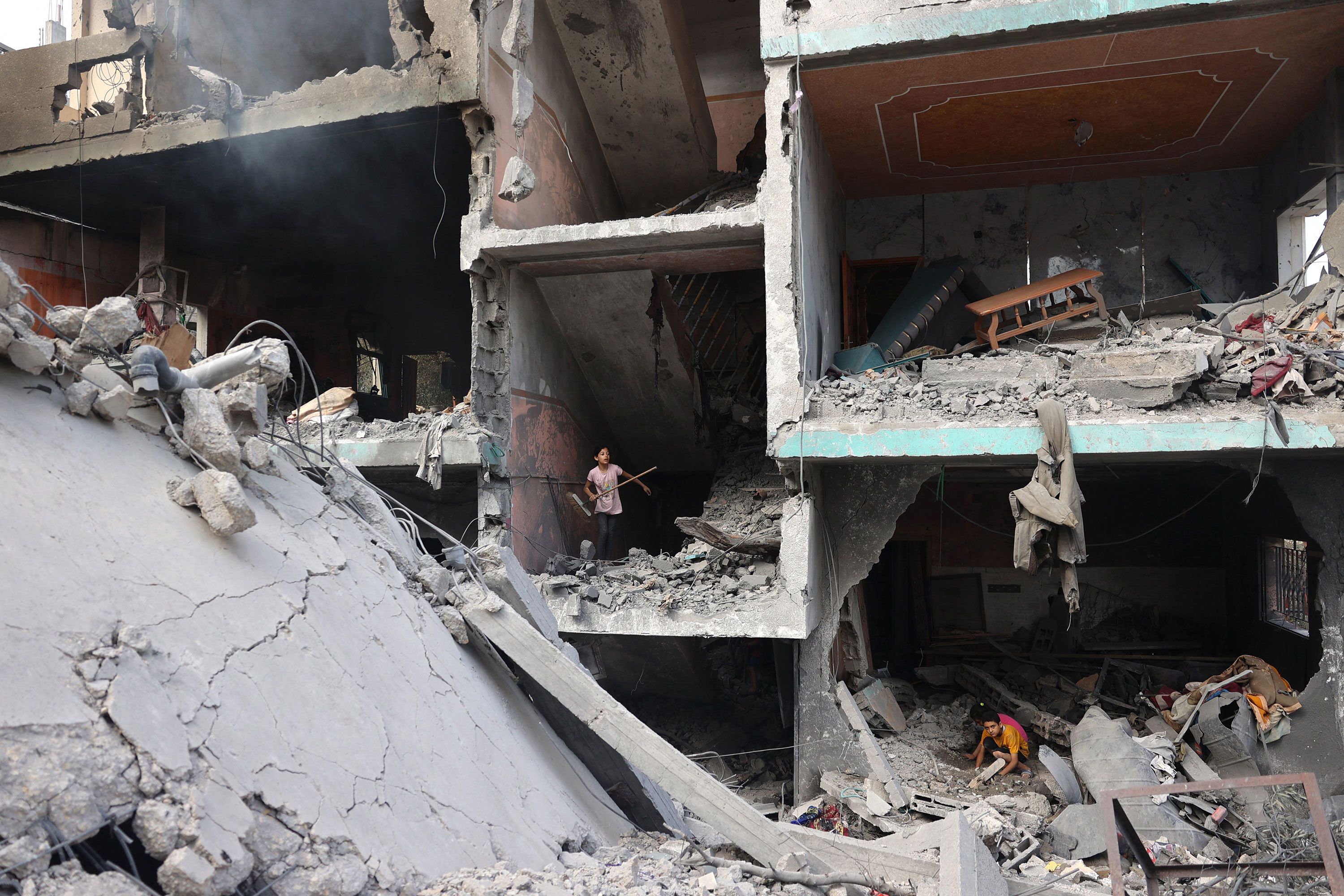 Palestinian children search through the rubble of their homes in the Nuseirat refugee camp in central Gaza on Sunday, June 9.