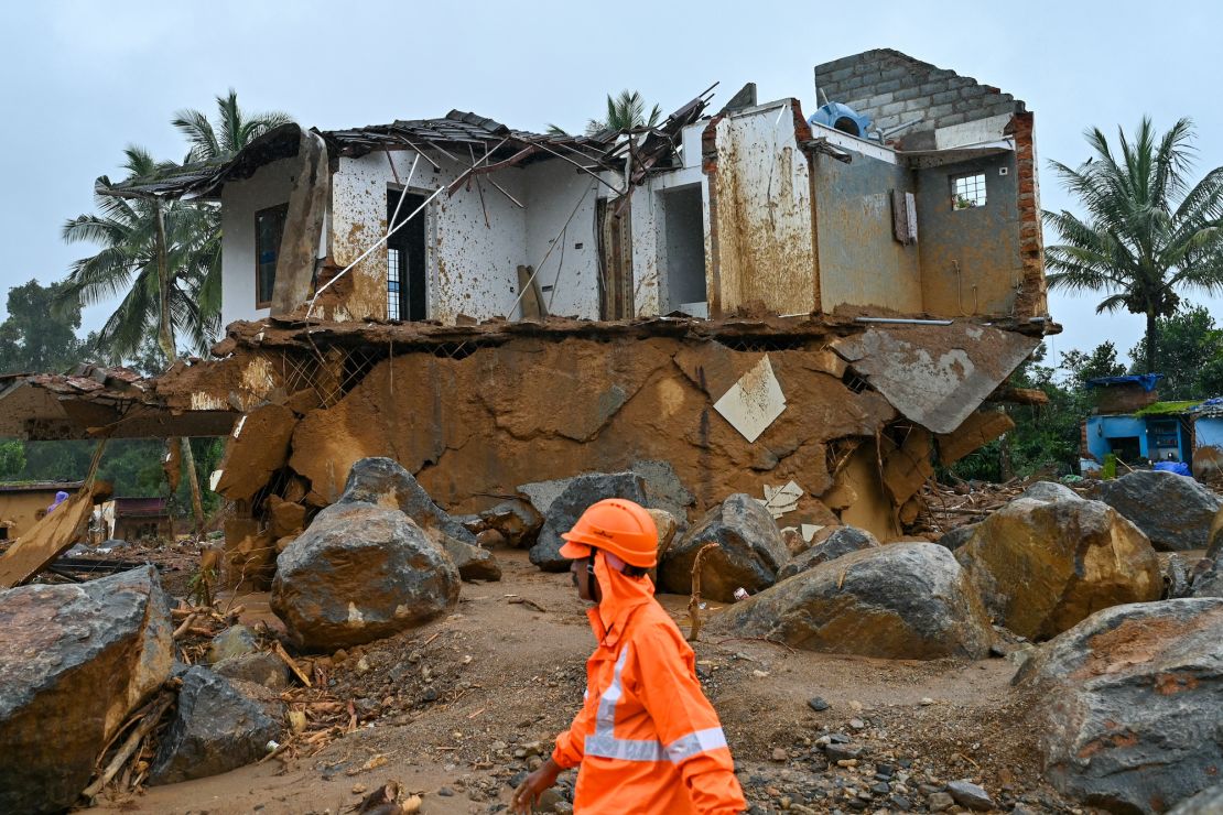 A rescue worker walks past a damaged house after the landslides in Wayanad on August 1, 2024.