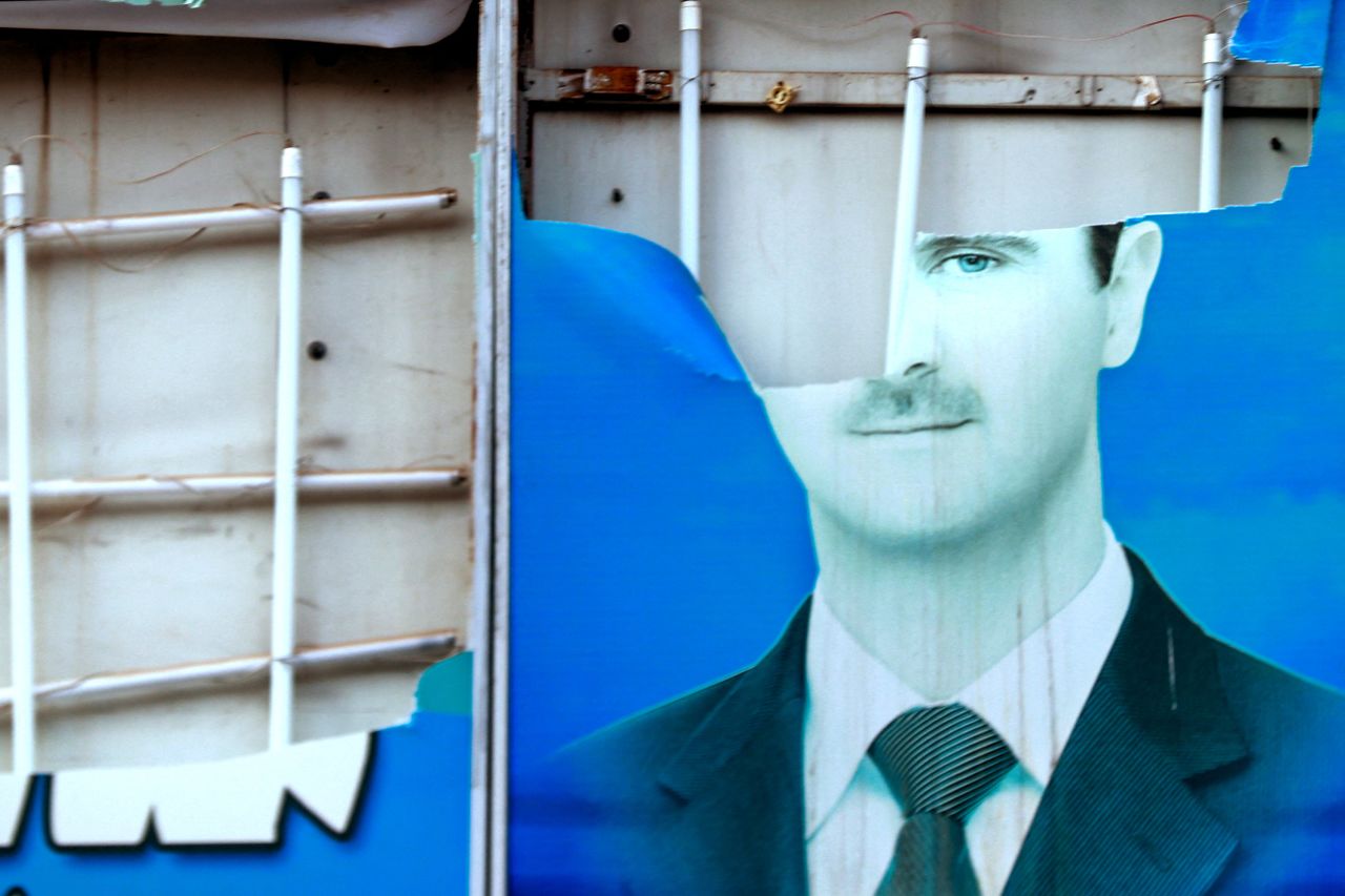 A damaged portrait of Syrian President Bashar al-Assad hangs in Qamishli, Syria, on December 8.