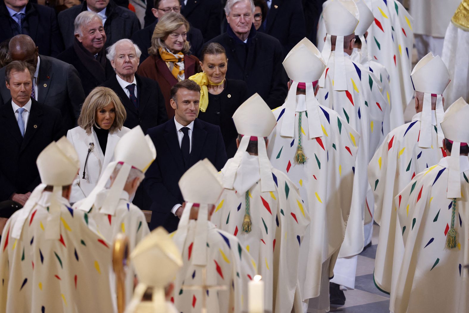 French President Emmanuel Macron and his wife Brigitte Macron look on as members of the clergy exit on December 8.