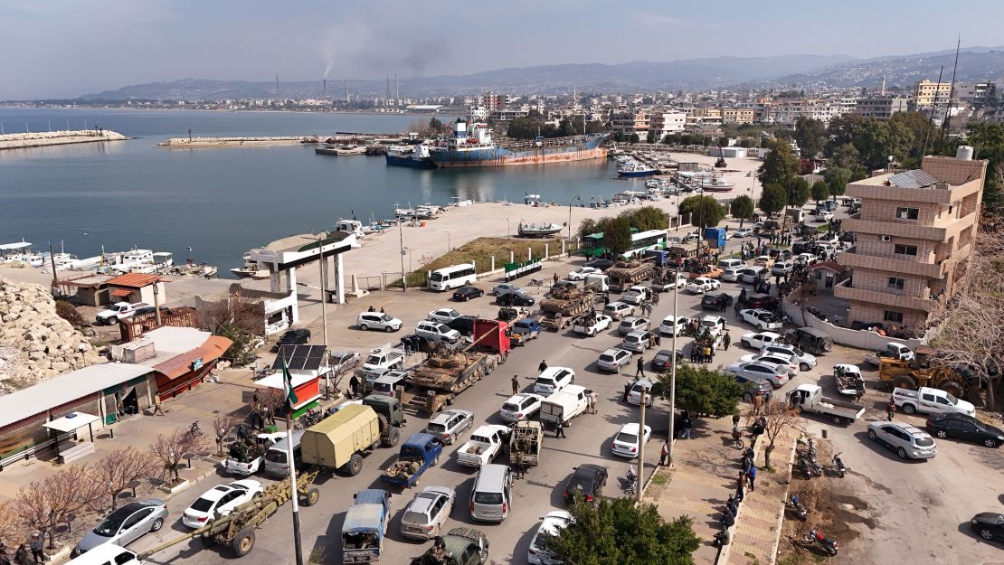 Syrian government fighters line a roadway in Baniyas, Syria, on Friday.