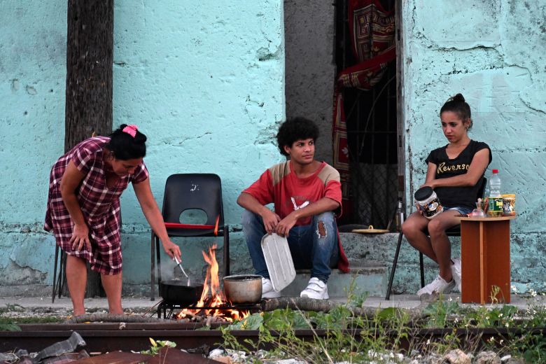 People cook outside their home during a nationwide blackout caused by a power grid failure in March.