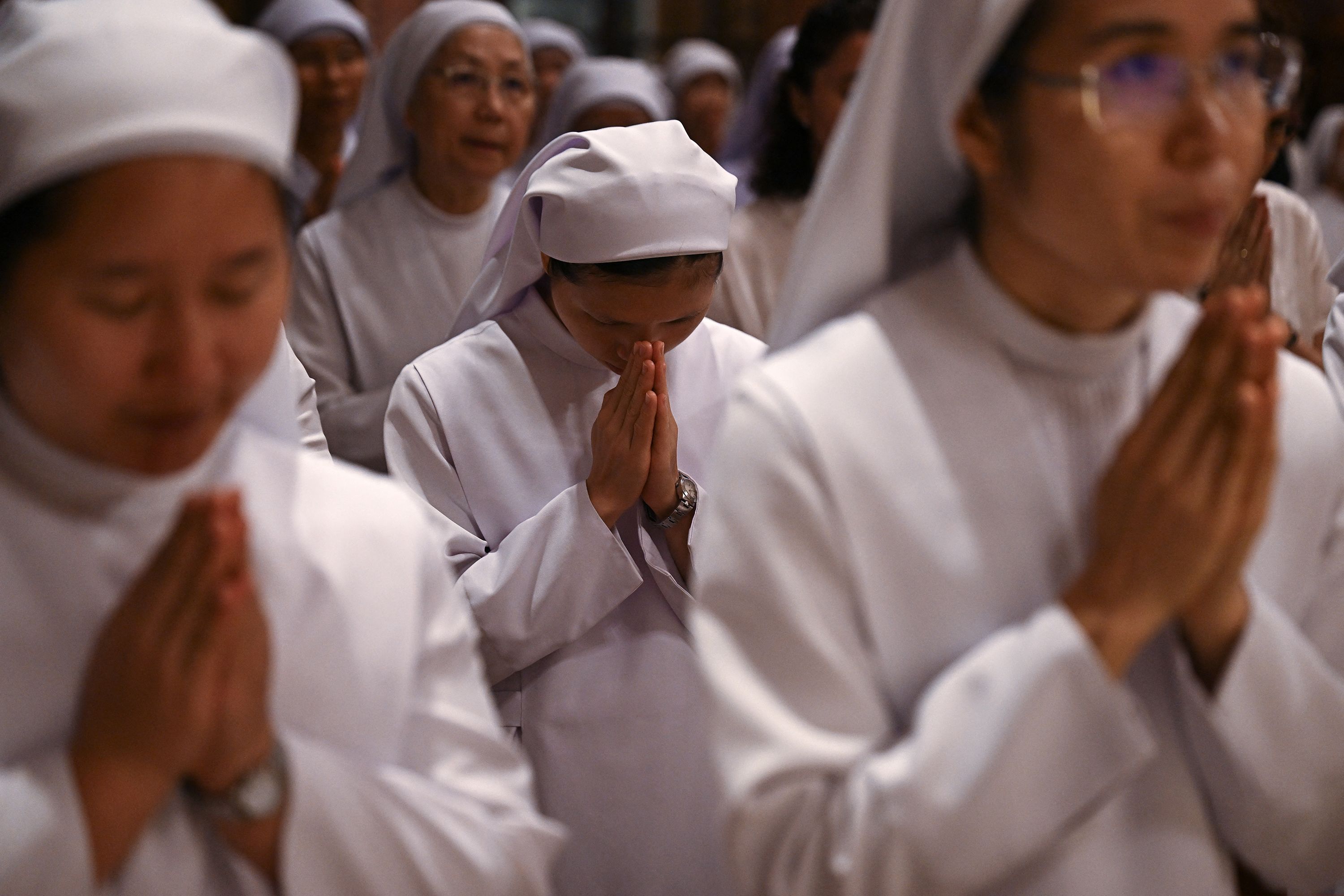 People pray for the pope during a Mass at the Assumption Cathedral in Bangkok.