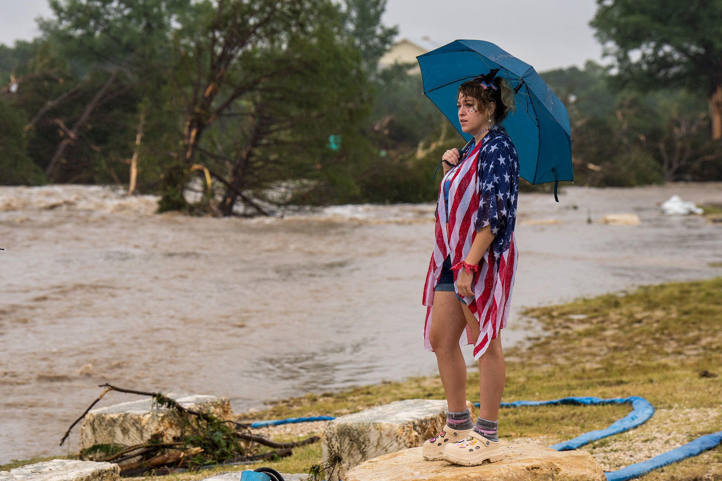 A woman watches flood waters along the Guadalupe River in Kerrville on Friday.