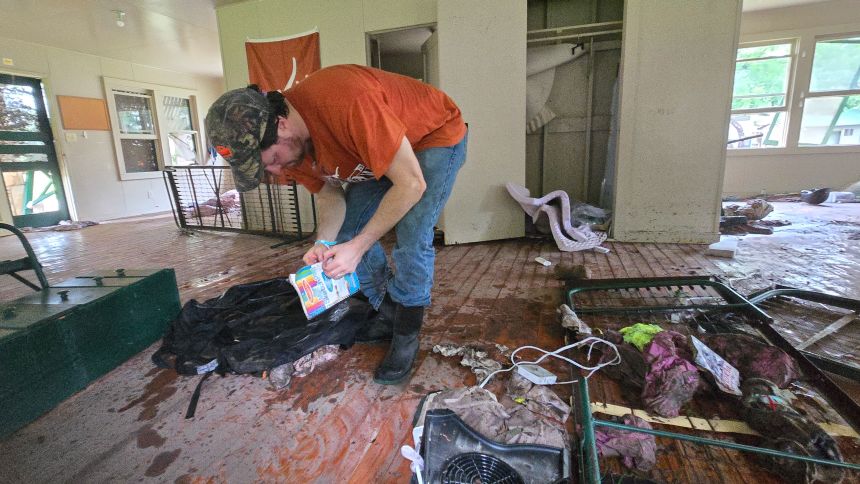 Michael McCown sifts through debris inside Bubble Inn. His 8-year-old daughter Linnie died in the flooding.