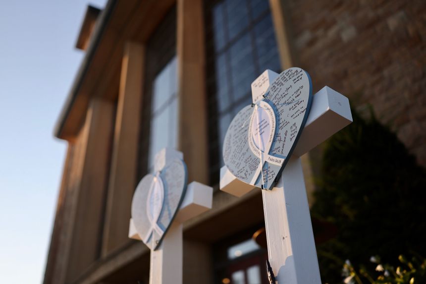 Flowers, candles and mementos are left near Annunciation Catholic School on Thursday.