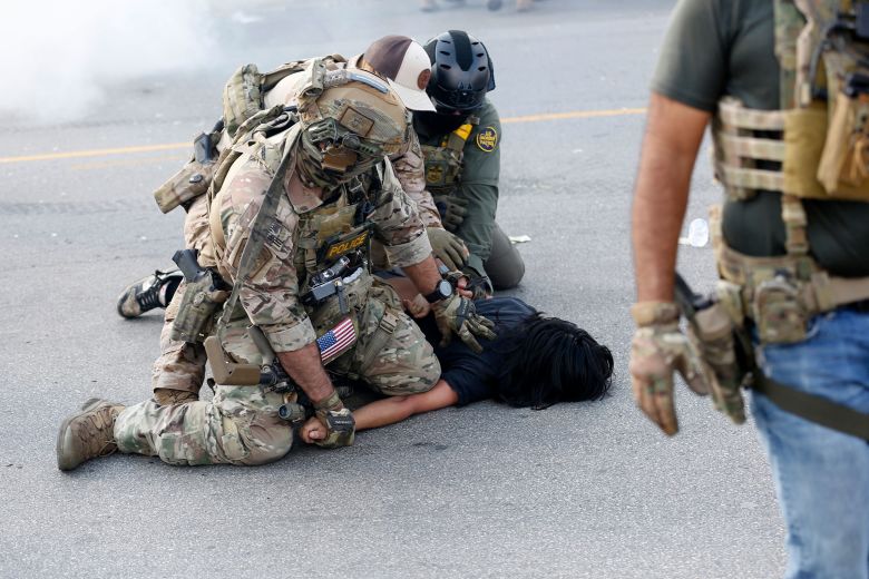A person is detained as residents of Chicago's Brighton Park neighborhood confront Border Patrol and other law enforcement agents, as agents allegedly detained an unidentified man.