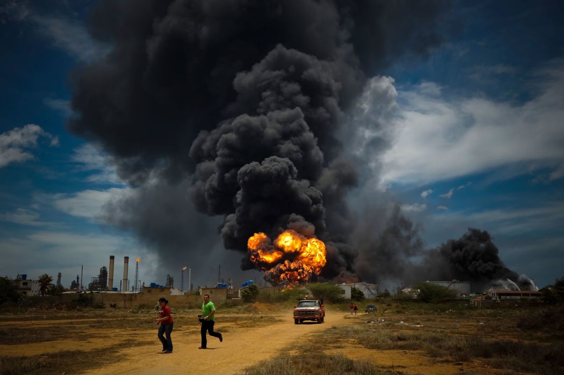 Fuel storage tanks burn after a vapor cloud explosion at the Amuay refinery in Punto Fijo, Venezuela, on August 27, 2012.